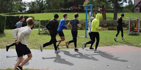 Powiększ grafikę: Grupa uczniów w trakcie biegu.