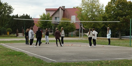 Powiększ grafikę: grupa uczniów na boisku siatkarskim.